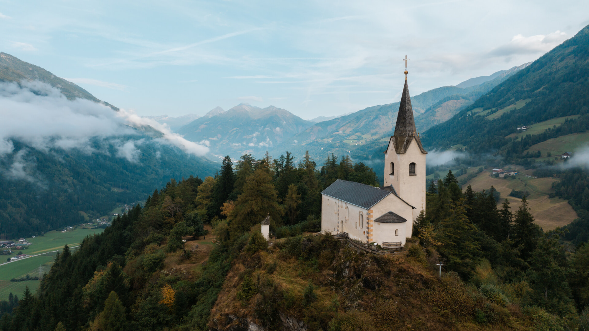 Die Kirche St. Georg auf der Spitze des Danielsbergs vor dem Bergpanorama